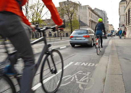 Fahrradfahrende, sowie ein Auto auf der Straße als Thumbnail für die Kategorie Mobilität